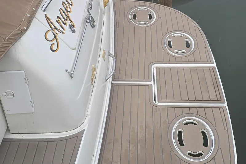 Slide: The Image of 1999 Sea Ray 340 Sundancer swim platform with teak decking and boat name visible. - 21