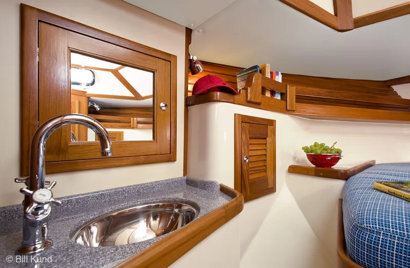 Slide: The Image of Interior of 2025 Pacific Seacraft 40 yacht with sink, wooden cabinetry, and cozy sleeping area. - 19