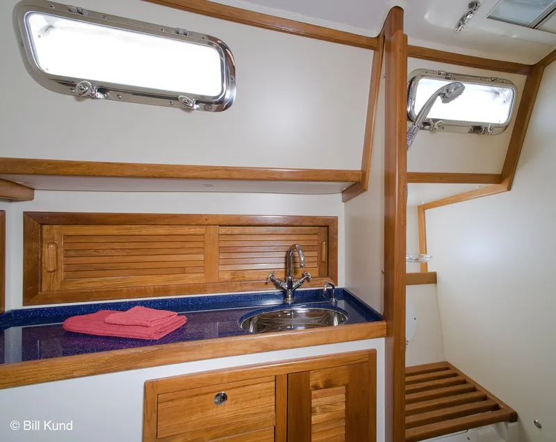 Slide: The Image of 2025 Pacific Seacraft 40 yacht interior with wooden cabinetry and sink. - 23