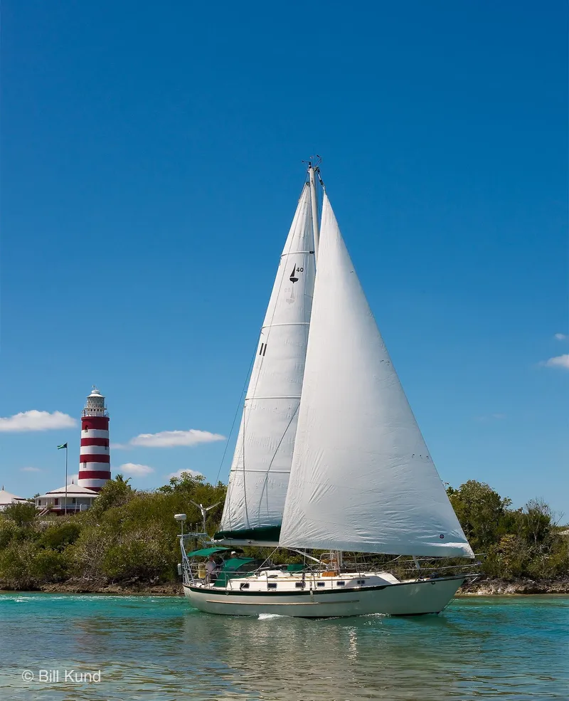 Slide: The Image of Sailboat Pacific Seacraft 40, 2025 model, sailing near a lighthouse under clear blue skies. - 8
