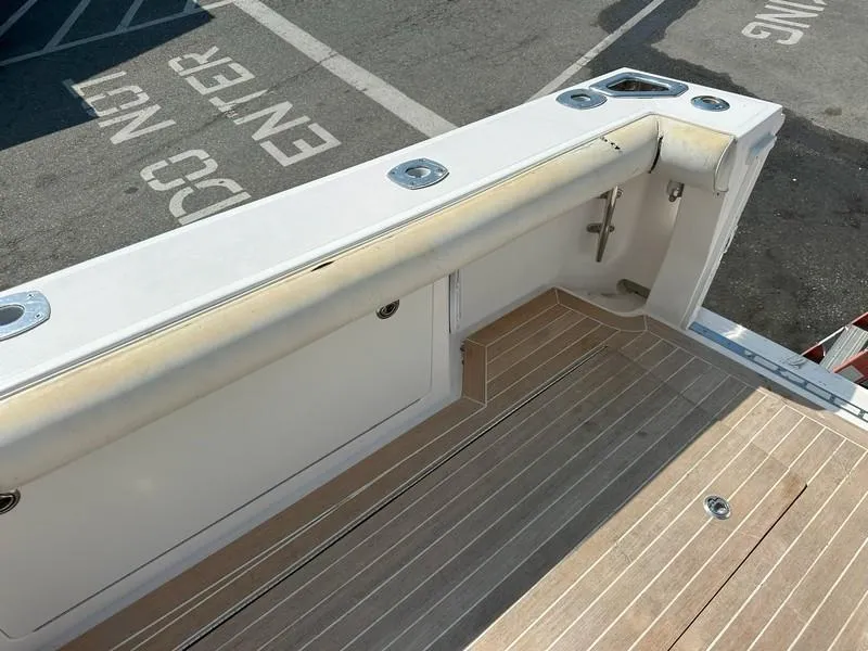 Slide: The Image of 2004 Cabo Express boat deck with wood finish and storage compartments. - 21