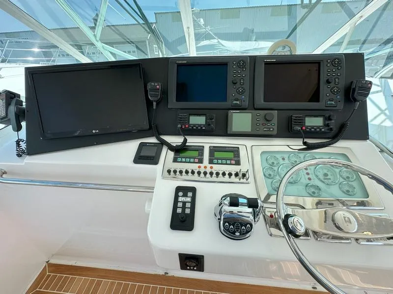 Slide: The Image of Control panel of a 2004 Cabo Express boat with navigation screens and steering wheel. - 28