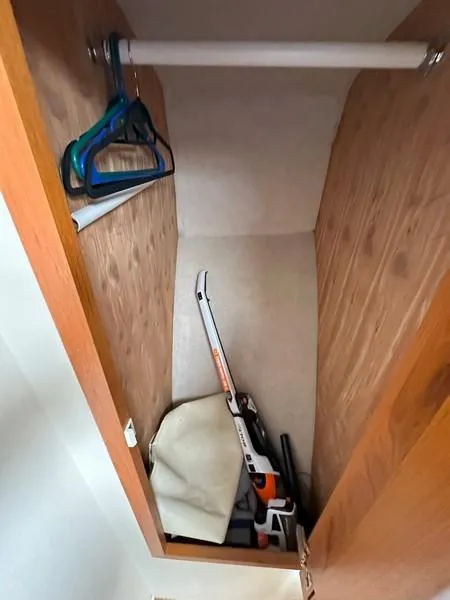 Slide: The Image of Small wooden closet with hangers and a stored chainsaw, Cabo Express 2004 model. - 44