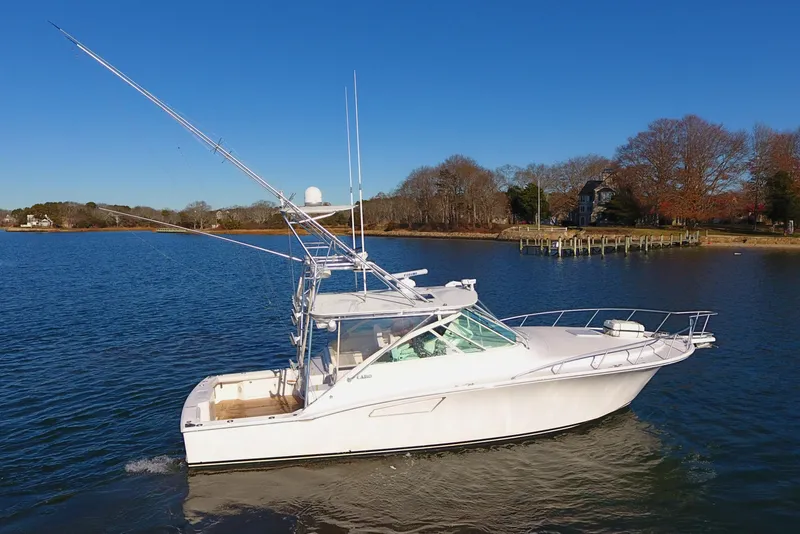 The Image of 2004 Cabo Express boat cruising on a calm lake with clear blue skies. - 0