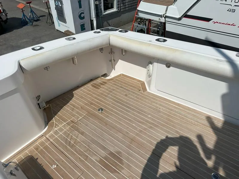 Slide: The Image of 2004 Cabo Express boat deck with wooden flooring and white railing. - 19