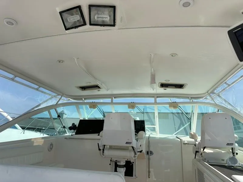 Slide: The Image of 2004 Cabo Express boat interior with helm chairs and navigation equipment. - 25