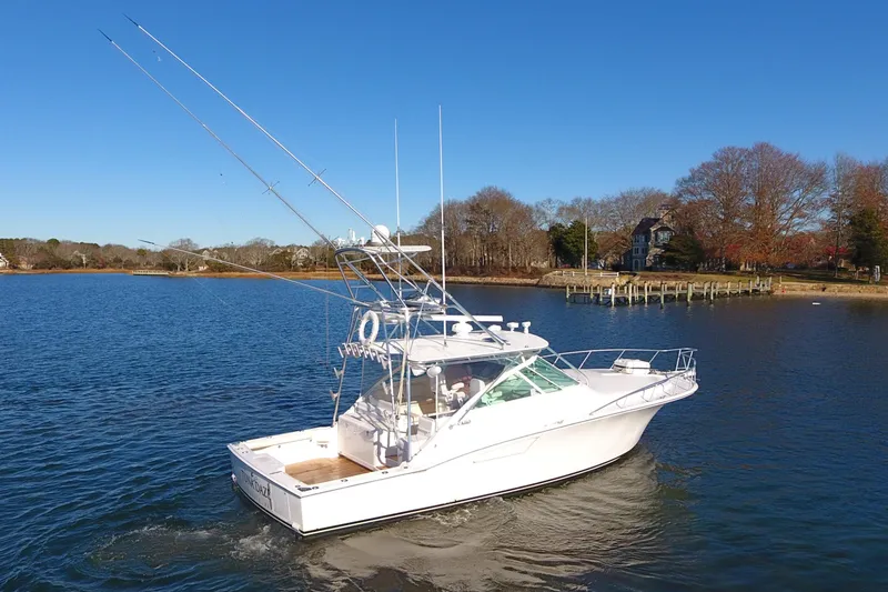 Slide: The Image of 2004 Cabo Express boat cruising on a calm lake under a clear blue sky. - 3