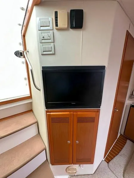 Slide: The Image of 2004 Cabo Express interior with TV, wooden cabinets, and stairs. - 34