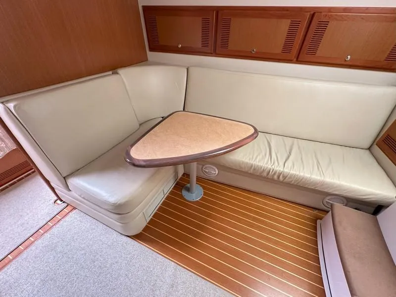 Slide: The Image of 2004 Cabo Express yacht interior with beige seating and wooden accents. - 36