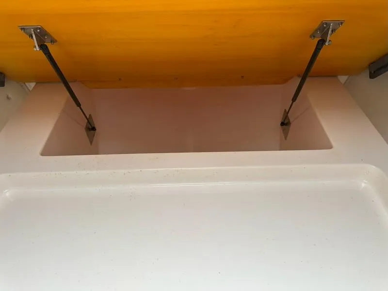 Slide: The Image of Open storage compartment with hydraulic supports in a 2004 Cabo Express boat. - 39