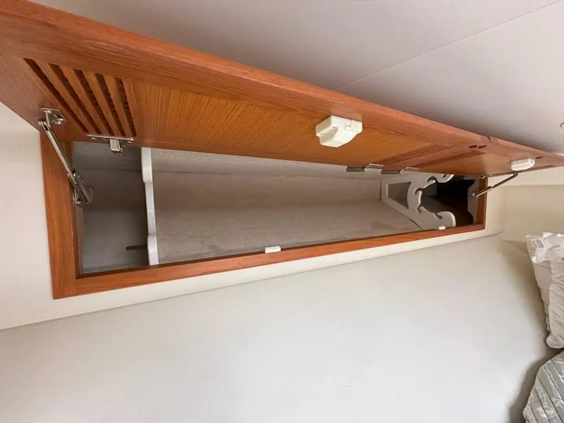 Slide: The Image of Open wooden cabinet in 2004 Cabo Express boat interior. - 45