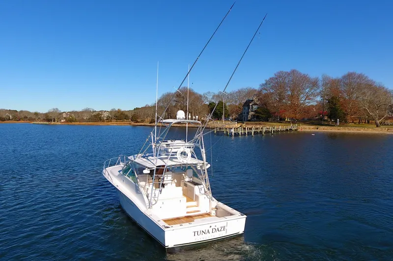 Slide: The Image of 2004 Cabo Express boat on calm water, clear sky, autumn trees in background. - 6