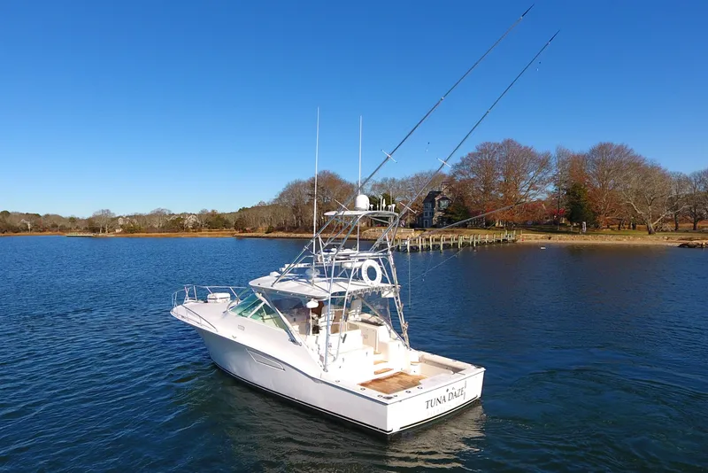 Slide: The Image of 2004 Cabo Express boat on calm water, clear sky, and scenic shoreline. - 7