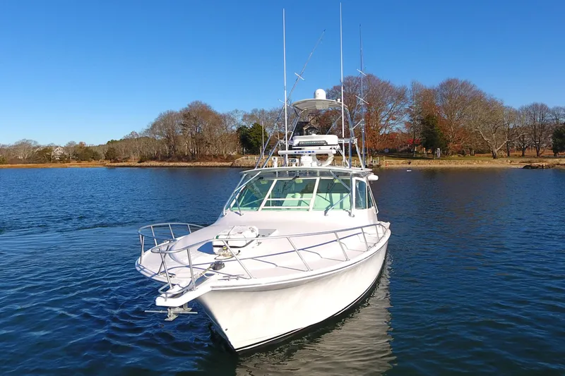 Slide: The Image of 2004 Cabo Express boat on calm water, clear sky, and wooded shoreline in the background. - 9