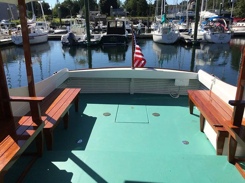 Slide: The Image of Classic Cruiser 1934 Hemingway's Pilar Replica docked, featuring wooden benches and American flag. - 7
