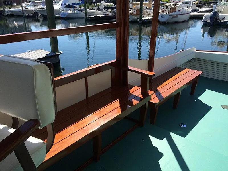 Slide: The Image of Classic Cruiser 1934 Hemingway's Pilar Replica with wooden benches, docked in a marina. - 9