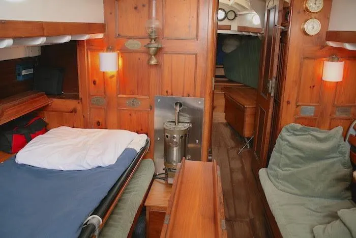 Slide: The Image of 1958 Concordia Yawl interior with wooden furnishings and cozy sleeping area. - 17