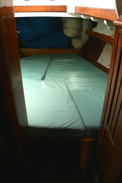 Slide: The Image of 1958 Concordia Yawl cabin with a cozy bed and wooden interior. - 8