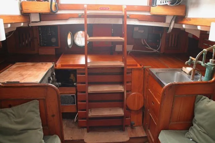 Slide: The Image of 1958 Concordia Yawl interior with wooden stairs, kitchen, and seating area. - 9