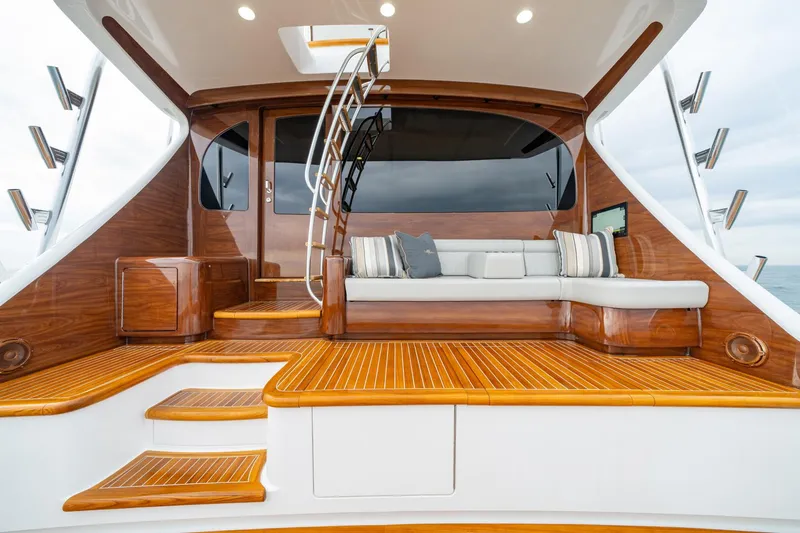 Slide: The Image of 2024 Viking 82 Convertible yacht with luxurious wooden deck and seating area. - 12