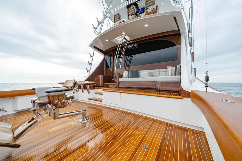 Slide: The Image of 2024 Viking 82 Convertible yacht with polished wooden deck and seating area. - 13