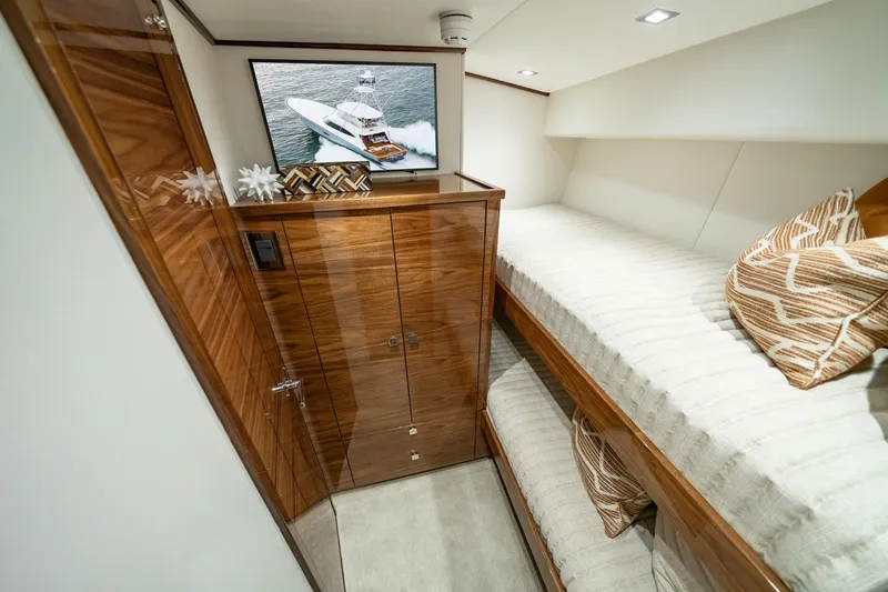 Slide: The Image of 2024 Viking 82 Convertible yacht interior with bunk beds and wooden cabinetry. - 15