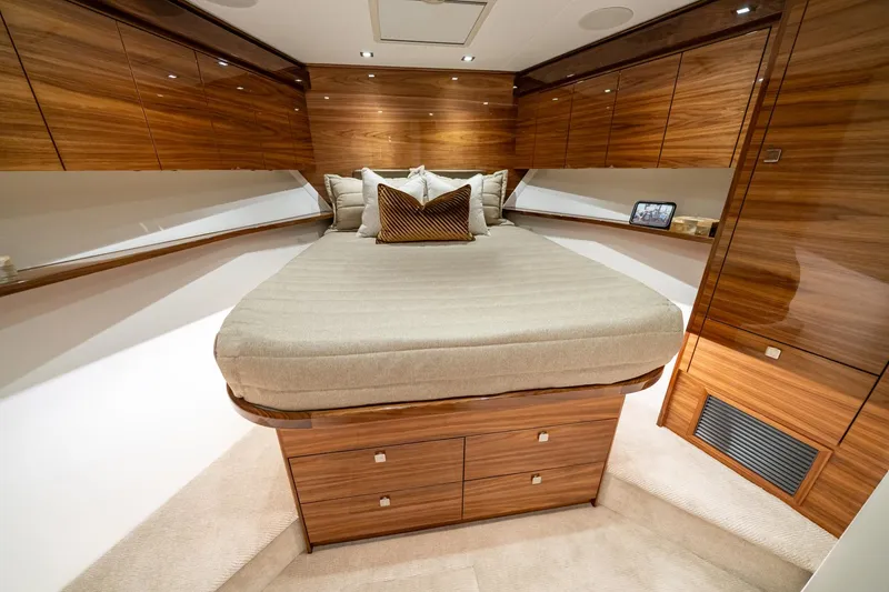 Slide: The Image of Luxurious bedroom interior of 2024 Viking 82 Convertible yacht with wooden cabinetry and plush bedding. - 16