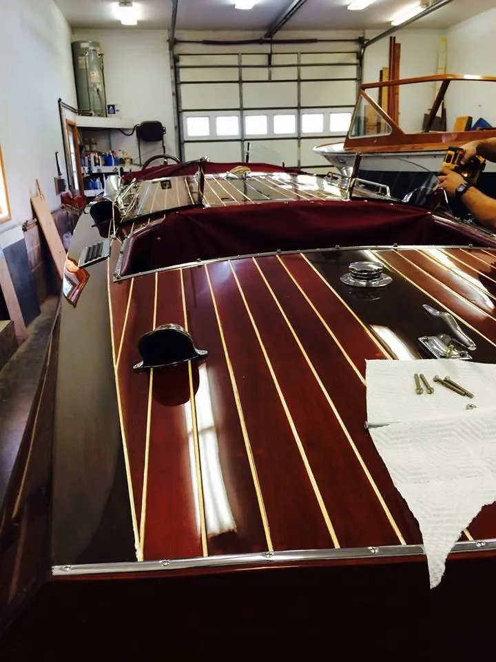 Slide: The Image of 1928 Hacker-Craft Dolphin boat with polished wooden deck in a garage setting. - 15