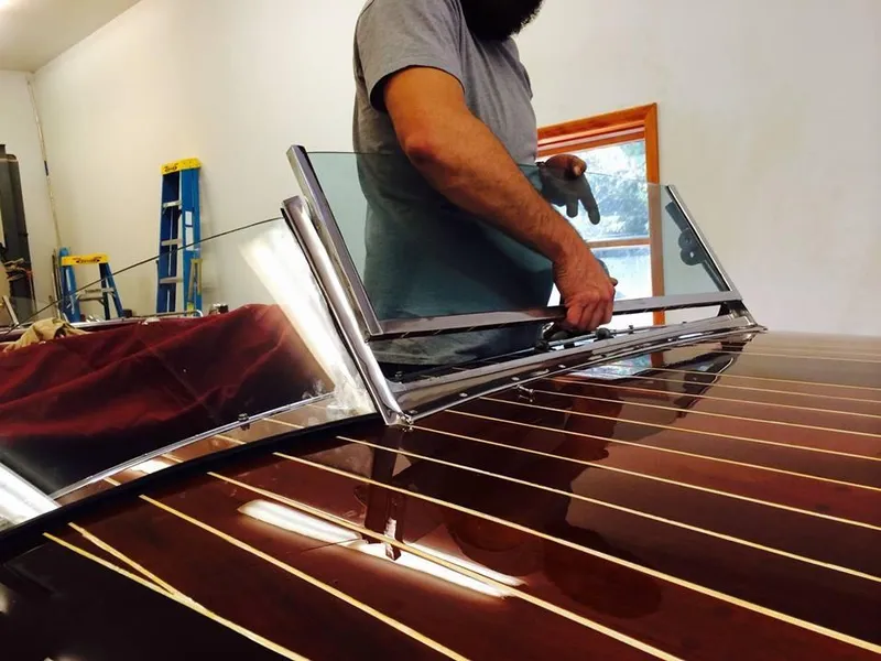 Slide: The Image of Man working on 1928 Hacker-Craft Dolphin boat windshield installation. - 16