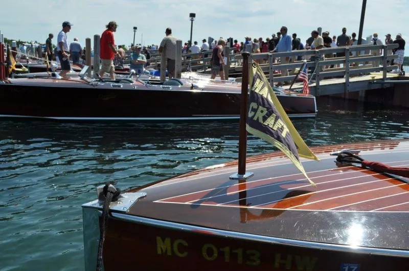 Slide: The Image of 1928 Hacker-Craft Dolphin boat at a crowded dock, showcasing classic wooden design. - 17