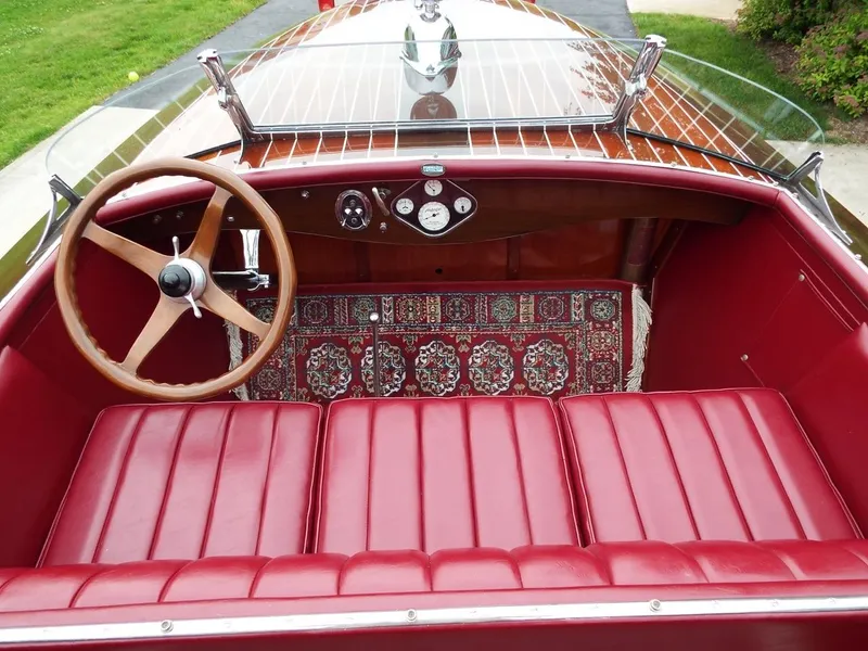 Slide: The Image of 1928 Hacker-Craft Dolphin boat interior with red leather seats and wooden steering wheel. - 7