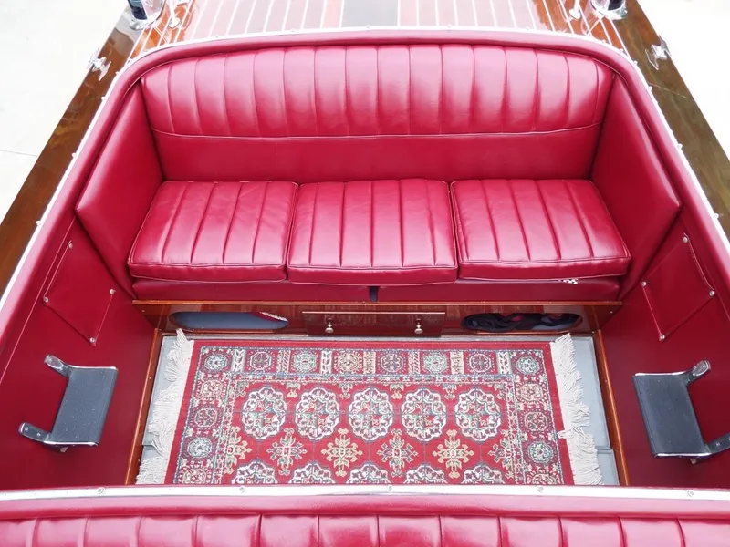 Slide: The Image of Luxurious 1928 Hacker-Craft Dolphin boat interior with red leather seats and ornate carpet. - 9