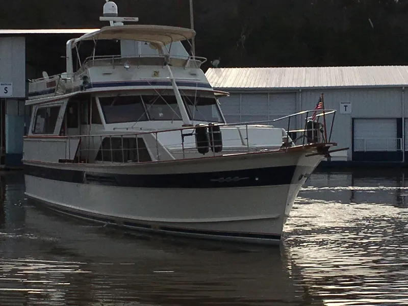 Slide: The Image of 1984 Chris-Craft Constellation yacht docked near a marina, featuring classic design and elegant lines. - 1