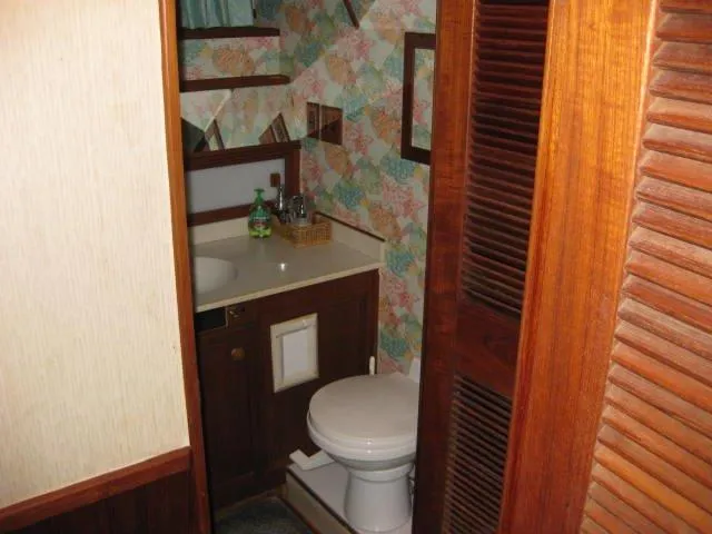 Slide: The Image of 1984 Chris-Craft Constellation bathroom with wooden accents and floral wallpaper. - 16