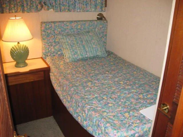 Slide: The Image of 1984 Chris-Craft Constellation cabin with floral bedding and a bedside lamp. - 18