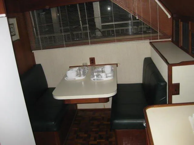 Slide: The Image of 1984 Chris-Craft Constellation interior dining area with booth seating and tableware. - 22