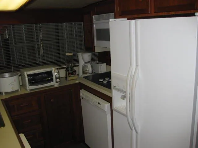 Slide: The Image of 1984 Chris-Craft Constellation kitchen with appliances, including fridge, microwave, and toaster oven. - 23