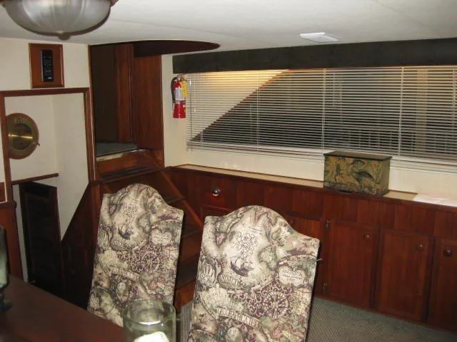 Slide: The Image of Interior of 1984 Chris-Craft Constellation yacht with elegant wood paneling and patterned chairs. - 25