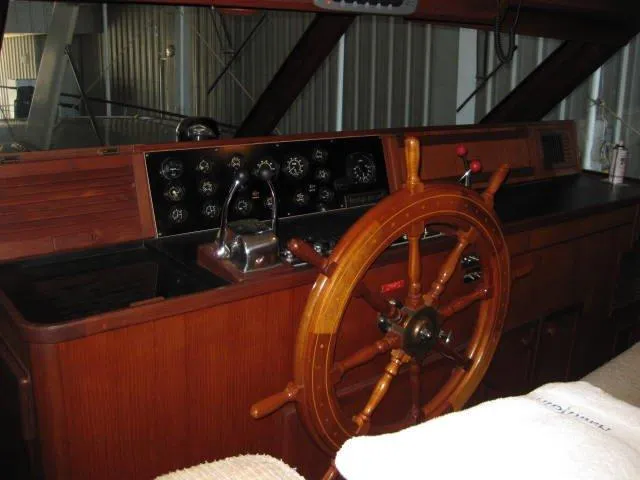 Slide: The Image of 1984 Chris-Craft Constellation helm with wooden steering wheel and classic instrument panel. - 27