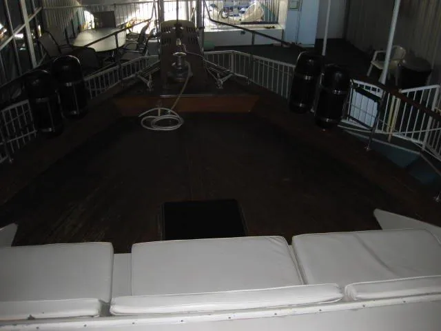 Slide: The Image of 1984 Chris-Craft Constellation boat interior with cushioned seating and wooden deck. - 39