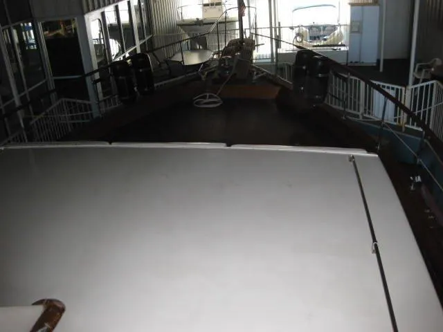 Slide: The Image of 1984 Chris-Craft Constellation yacht docked indoors, showcasing deck and railing. - 40