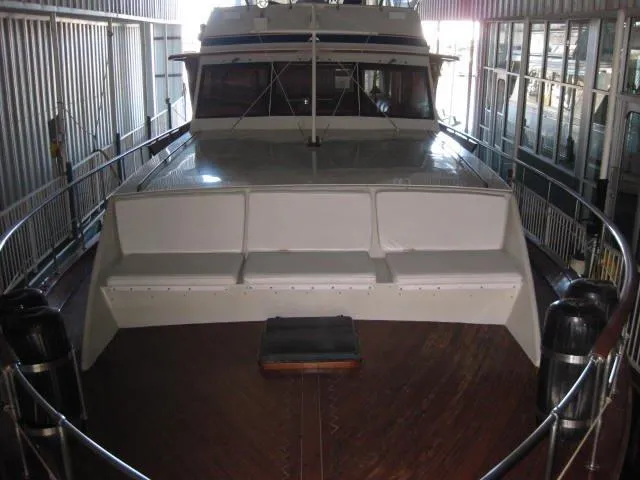 Slide: The Image of 1984 Chris-Craft Constellation yacht docked indoors, featuring spacious deck seating. - 42