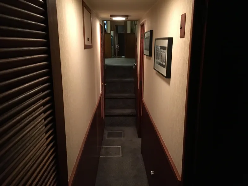 Slide: The Image of Narrow hallway inside 1984 Chris-Craft Constellation yacht, featuring carpeted floor and framed artwork. - 43
