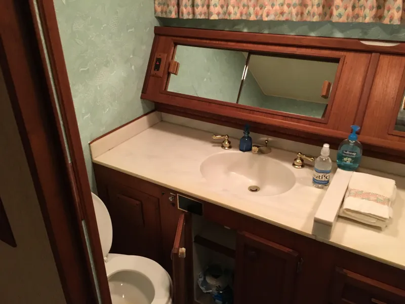 Slide: The Image of Bathroom interior of 1984 Chris-Craft Constellation yacht with wooden cabinetry and sink. - 44