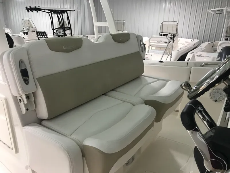 Slide: The Image of 2024 Robalo R302 boat interior with cushioned seating and steering console. - 12