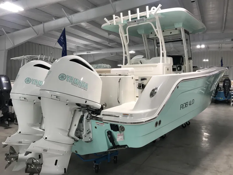 Slide: The Image of 2024 Robalo R302 boat with twin Yamaha engines in a showroom. - 3