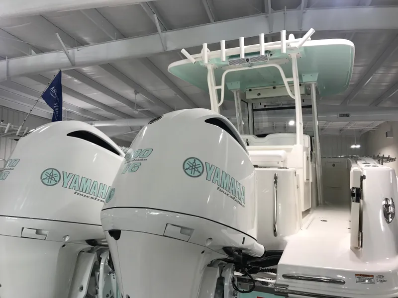 Slide: The Image of 2024 Robalo R302 boat with twin Yamaha outboard engines in a showroom. - 4