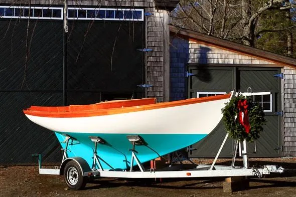 Slide: The Image of 2011 Herreshoff Fish Class boat on trailer, adorned with a festive wreath. - 5