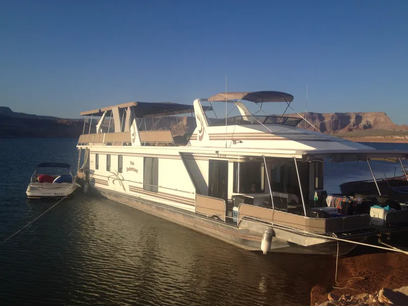 The Image of Houseboat "Pure Enchantment Trip 24 & 34" by Stardust Cruisers, 2000, docked on a serene lake. - 1