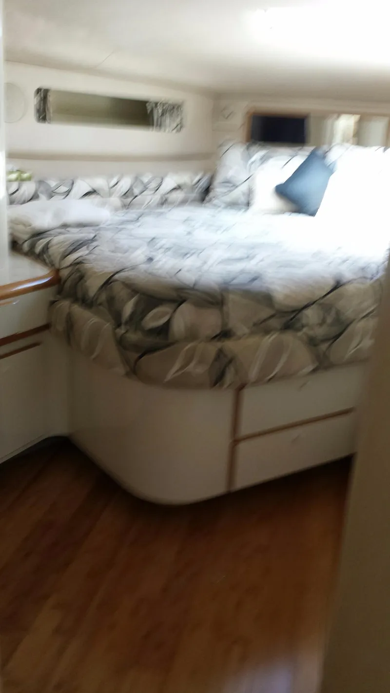 Slide: The Image of 1996 Sea Ray 500 Sundancer cabin with bed and wooden flooring. - 14